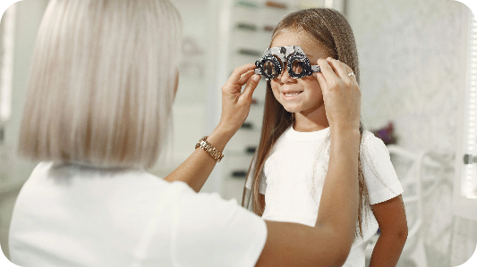 A young girl having her eyes tested by an optometrist.